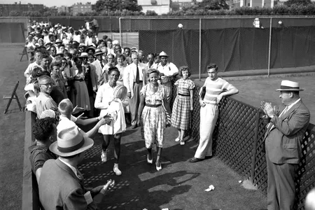 Althea Gibson leaves Forest Hills court accompanied by Alice Marble and applause of spectators.