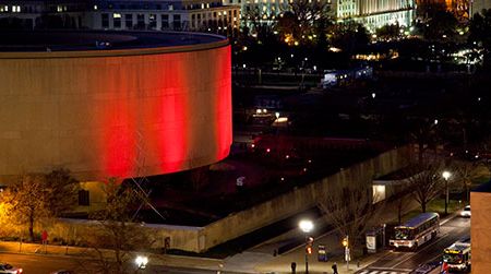 The Hirshhorn Museum is illuminated red in honor of World AIDS Day