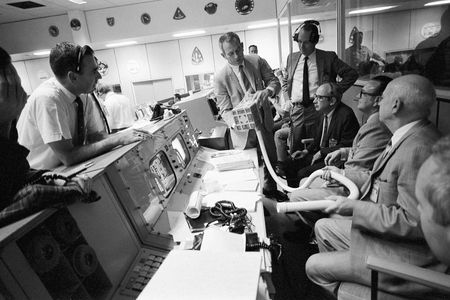 A group of astronauts and flight controllers monitor the action in Mission Control during the Apollo 13 mission.