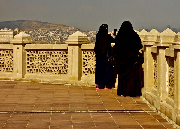 Two Young Girls in Muslim Dress Photograph the Caspian Sea from a Mosque thumbnail