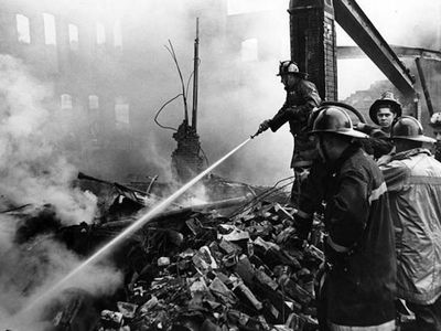 Fire fighters attempt to douse a smoldering building on Superior following the shootout in the Glenville neighborhood of Cleveland on July 23, 1968. 