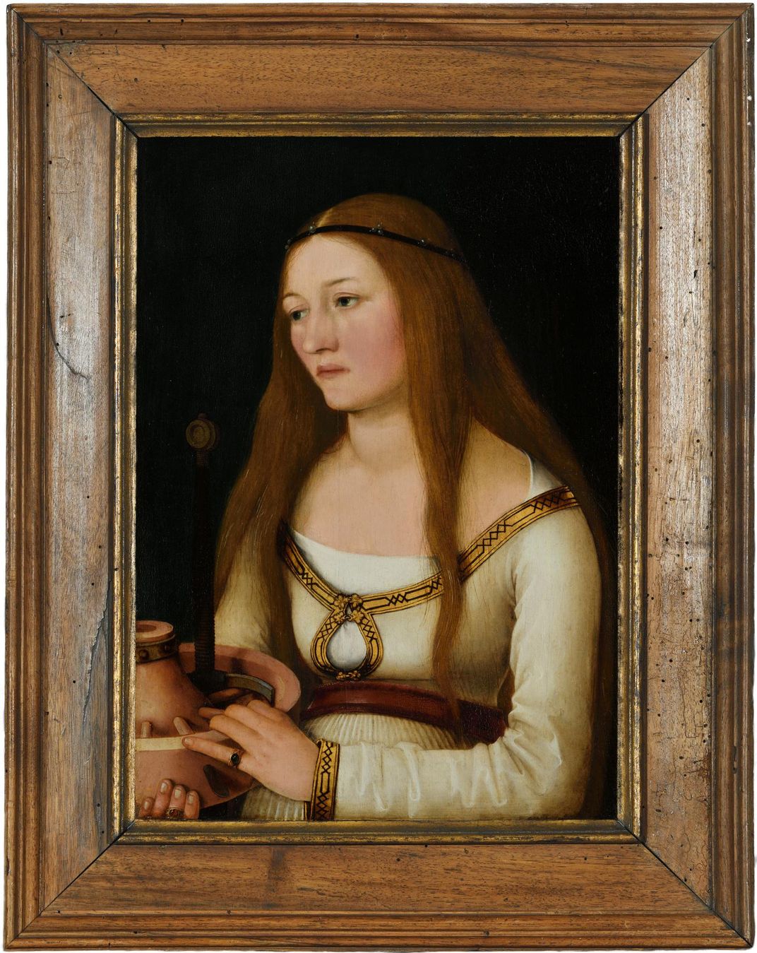 A portrait of a woman with long hair, holding a wheel and spoke and looking somber