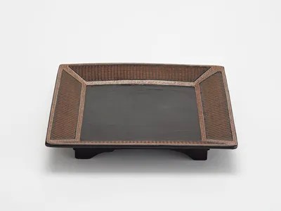 The dark black lacquered center of the Ming Dynasty tray, surrounded by an elegant basket weave design, made it seem almost modern.
