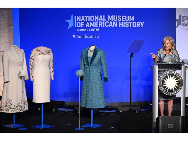 Jill Biden addresses a crowd at the Smithsonian&#39;s National Museum of American History on January 25. Inaugural ensembles by Gabriella Hearst (left) and Alexandra O&#39;Neill (right) stand next to her.
