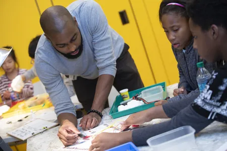 Museum educator Christopher Williams engages with student visitors during a Community Day in 2018. (Leah Jones, National Museum of African American History and Culture)