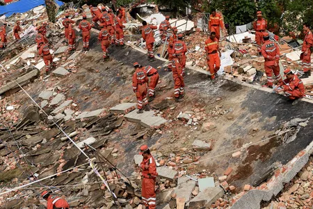 Rescue workers look through the ruins left by the August 3, 2014 earthquake.