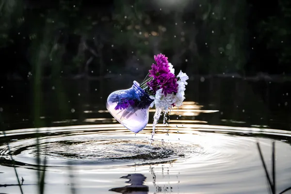 Flowers in a vase pour above a steam like a fountain thumbnail