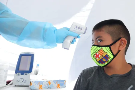 A boy has his temperature checked as he receives a free COVID-19 test in Los Angeles.