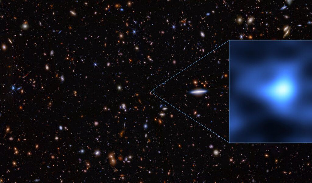 an image of several distant galaxies, with a zoom window showing JADES-GS-z14-0 as a fuzzy blue