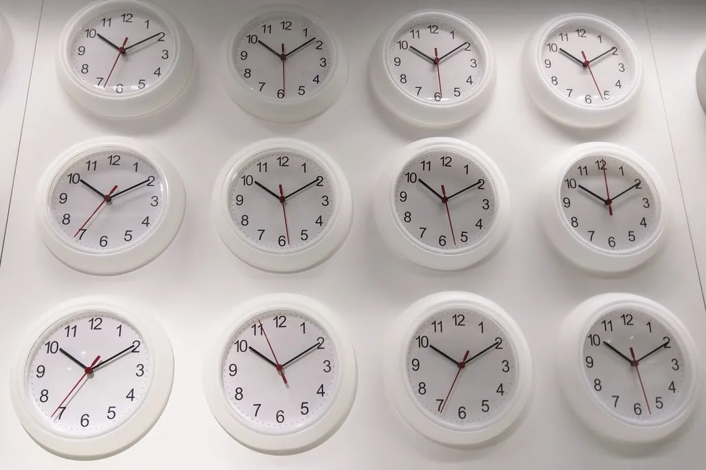 a wall of white clocks