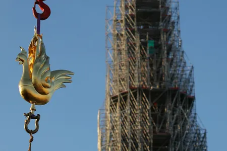 A crane lifts the new golden rooster to the top of Notre-Dame Cathedral's spire on December 16, 2023.
