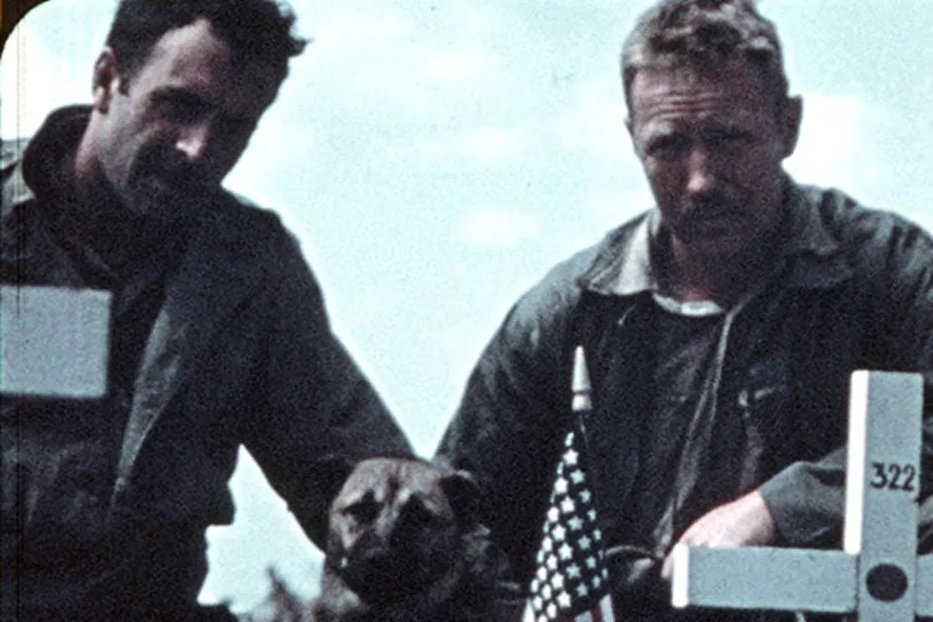 Two Marins near a cross that is inscribed with the number 322