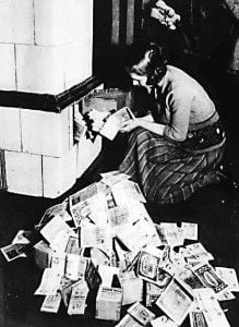 Cheap fuel. A German woman fires her boiler with wads of billion mark notes, autumn 1923.