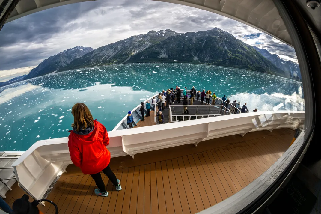 A tourist admires the landscape in Tarr Inlet aboard a cruise ship.