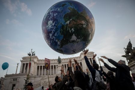 A crowd sends aloft a balloon representation of Earth at Piazza Venezia during a climate change rally in Rome a day before the COP21 conference in Paris.