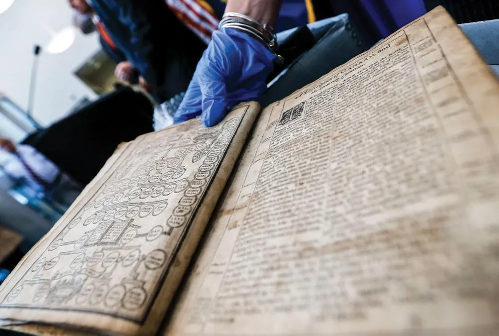 bible being held by blue-gloved hand