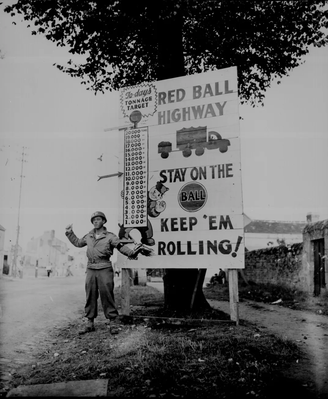 In this September 5, 1944, photograph, Corporal Charles H. Johnson of the 783rd Military Police Battalion waves on a Red Ball Express convoy near Alenon, France.