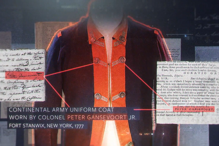 Continental Army uniform coat display with labeled text and document excerpts connected by lines to the coat.