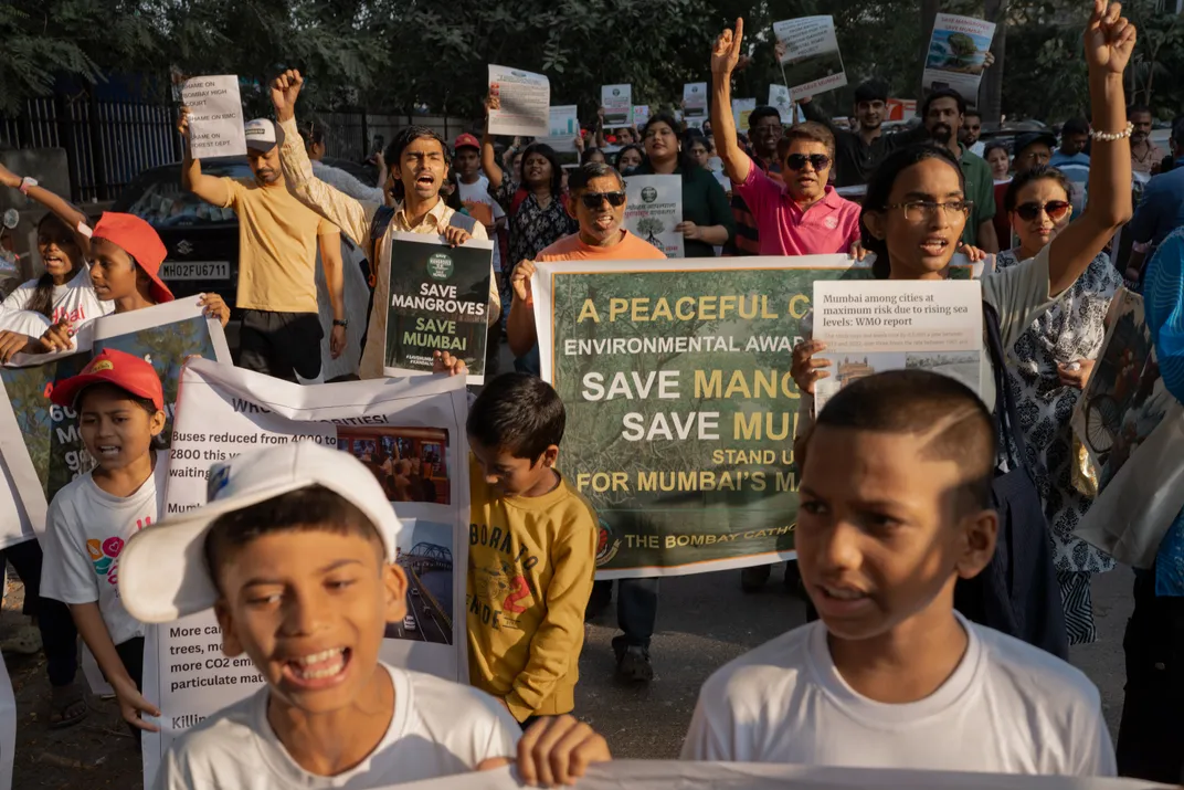 young protesters walk with signs that read "save mangroves. save Mumbai"