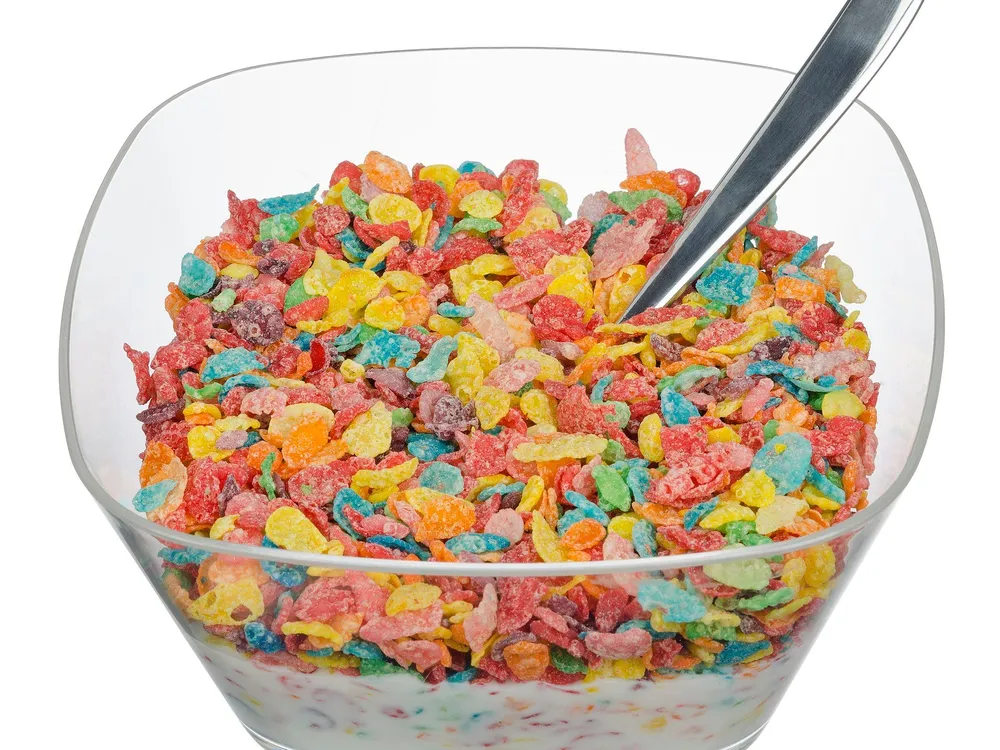 Fruity Pebbles cereal with milk in a clear plastic bowl.