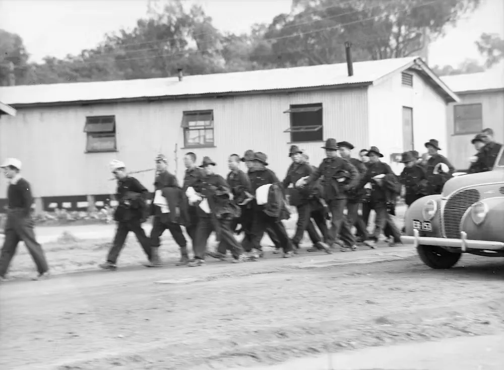 Japanese POWs at Cowra returning to their huts with newly issued clothing in July 1944