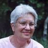 Vera Rubin in front of a green wooded area.