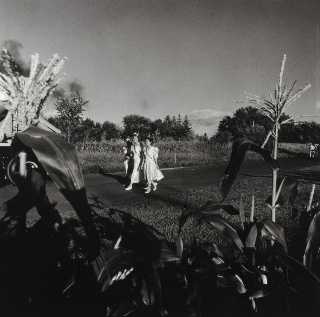 A photograph of three figures walking down a street. 