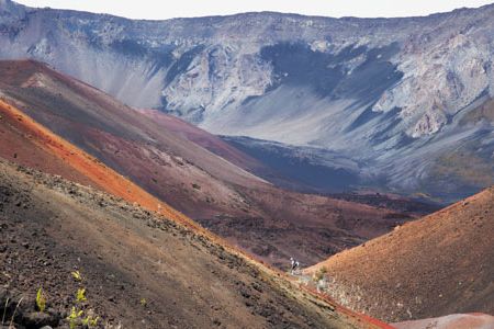 From cinder desert to tropical forest, the 19-square-mile Haleakala Crater boasts varied landscape. In the center is a hiker at "Pele's Paint Pot," likely named for the goddess of fire and volcanoes.