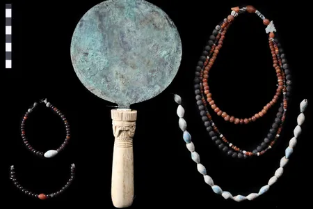 An engraved mirror and beaded jewelry discovered at the ancient family tomb near Luxor