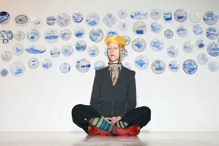 Julie Green poses in front of a selection of&nbsp;The Last Supper&nbsp;plates in 2015. The artist died on October 12 at age 60.