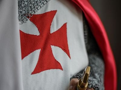 Knights of the SMOTJ wear the red cross pattée, believed to have been first used by the Knights Templar in 1147.