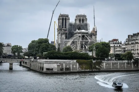 A police boat cruises along the River Seine past the Notre-Dame de Paris Cathedral, which was badly damaged by a huge fire on April 15, and which is under repair, on May 20, 2019.