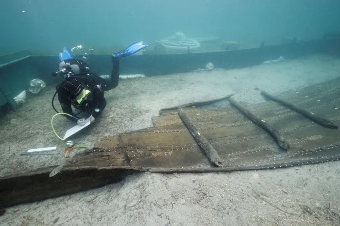 Underwater researcher exploring flat piece of shipwreck