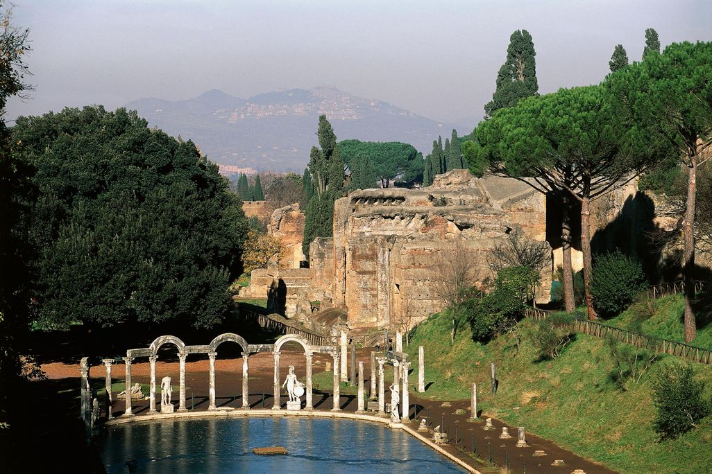 A view of a shallow pool of water with columns and crumbling structures extending behind