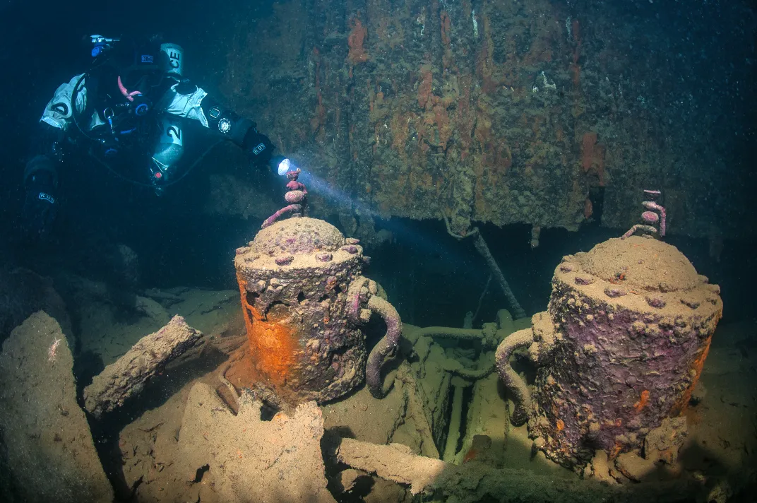 A diver looking at a shipwreck underwater