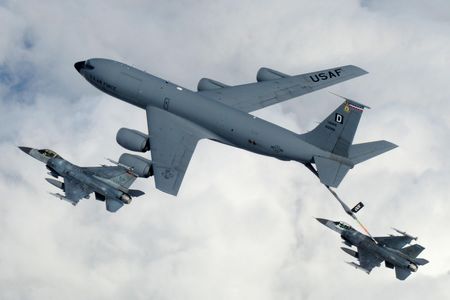 A KC-135 Stratotanker from Royal Air Force Mildenhall, England, refuels a pair of F-16 Fighting Falcons in flight.