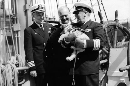 A dog mascot named Whisky in the arms of his captain Wolfgang Erhart on board a German ship in the harbor of New York in 1962 