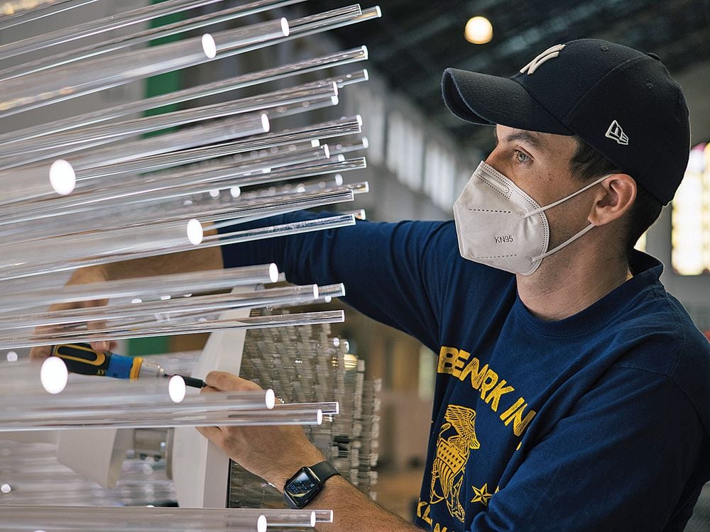 a worker installs an art installation