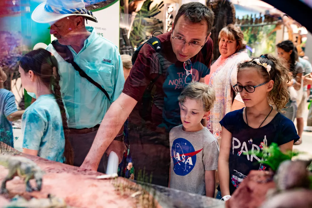 A father reads an exhibit label to his two children at the Smithsonian's National Museum of Natural History