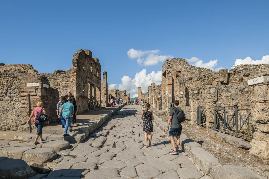 Travelers walking among the ruins at Pompeii