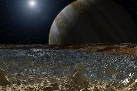 An artist&#39;s concept of a simulated view from the rough, icy surface of the moon Europa with Jupiter looming over the horizon.