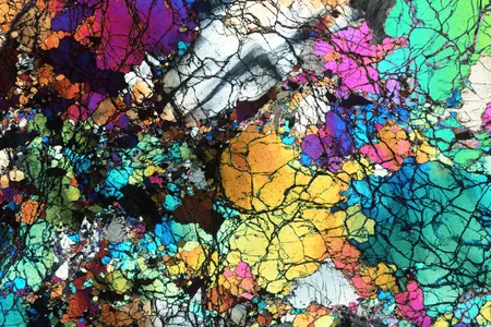 A thin slice of the ancient rocks collected from Gakkel Ridge near the North Pole, photographed under a microscope and seen under cross-polarized light