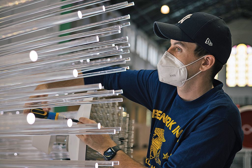 a worker installs an art installation