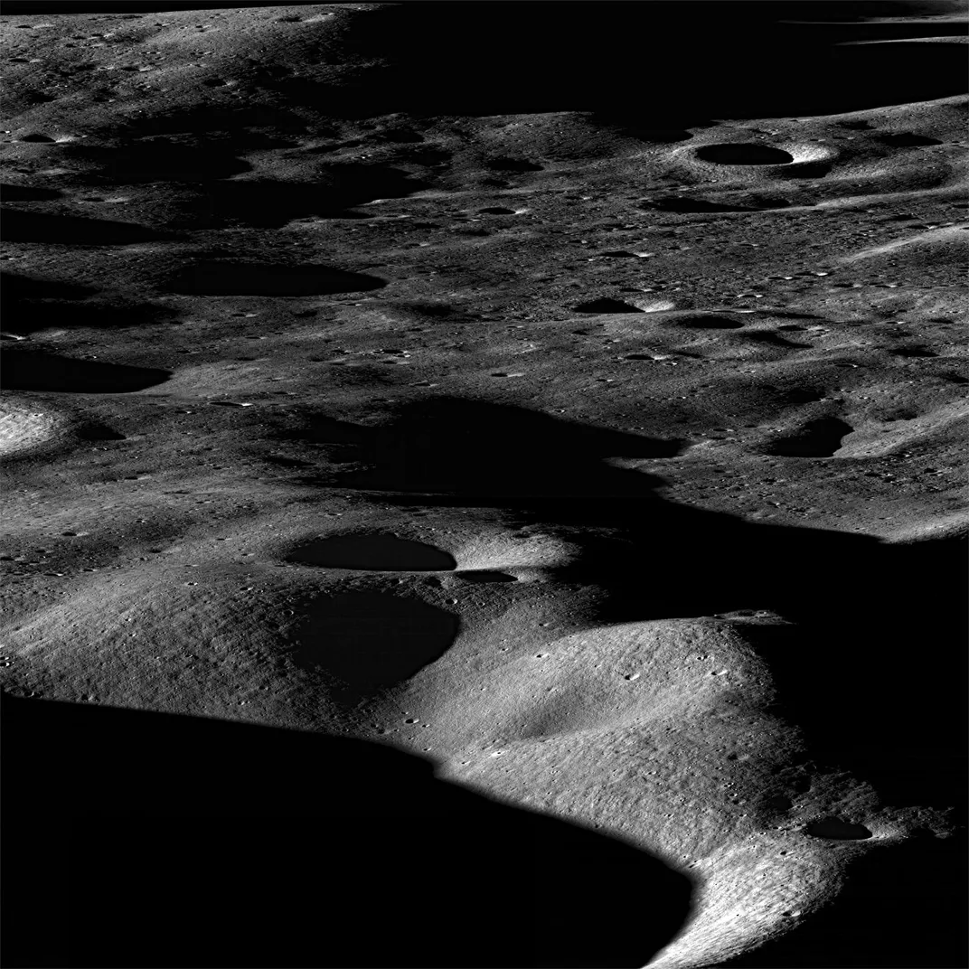 A shadowy image of mountains and craters across the moon's surface