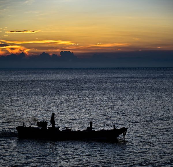 Fisherman at sunset on the beach thumbnail