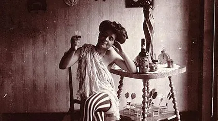 Storyville. Seated woman wearing striped stockings, drinking "Raleigh" Rye.