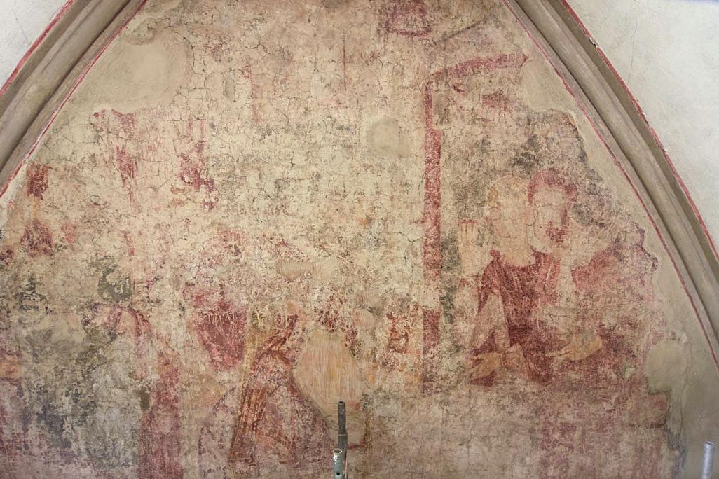 A very faded red and taupe frescoe with the outlines of some figures visible, enclosed in an arched dome