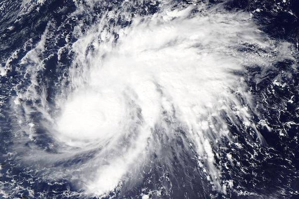 A satellite photo of Super Typhoon Goni. It shows Goni, a large, white, swirling storm moving over the blue Pacific ocean