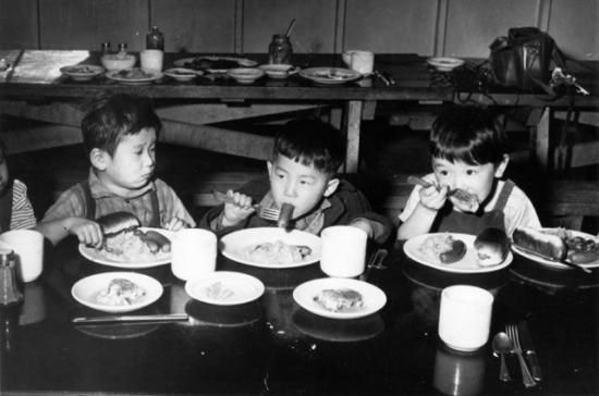 Black and white photo of three children eating