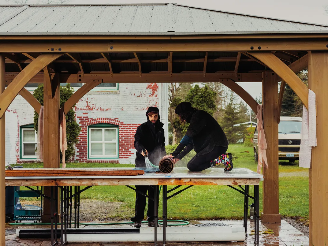 two people work on a table top outside